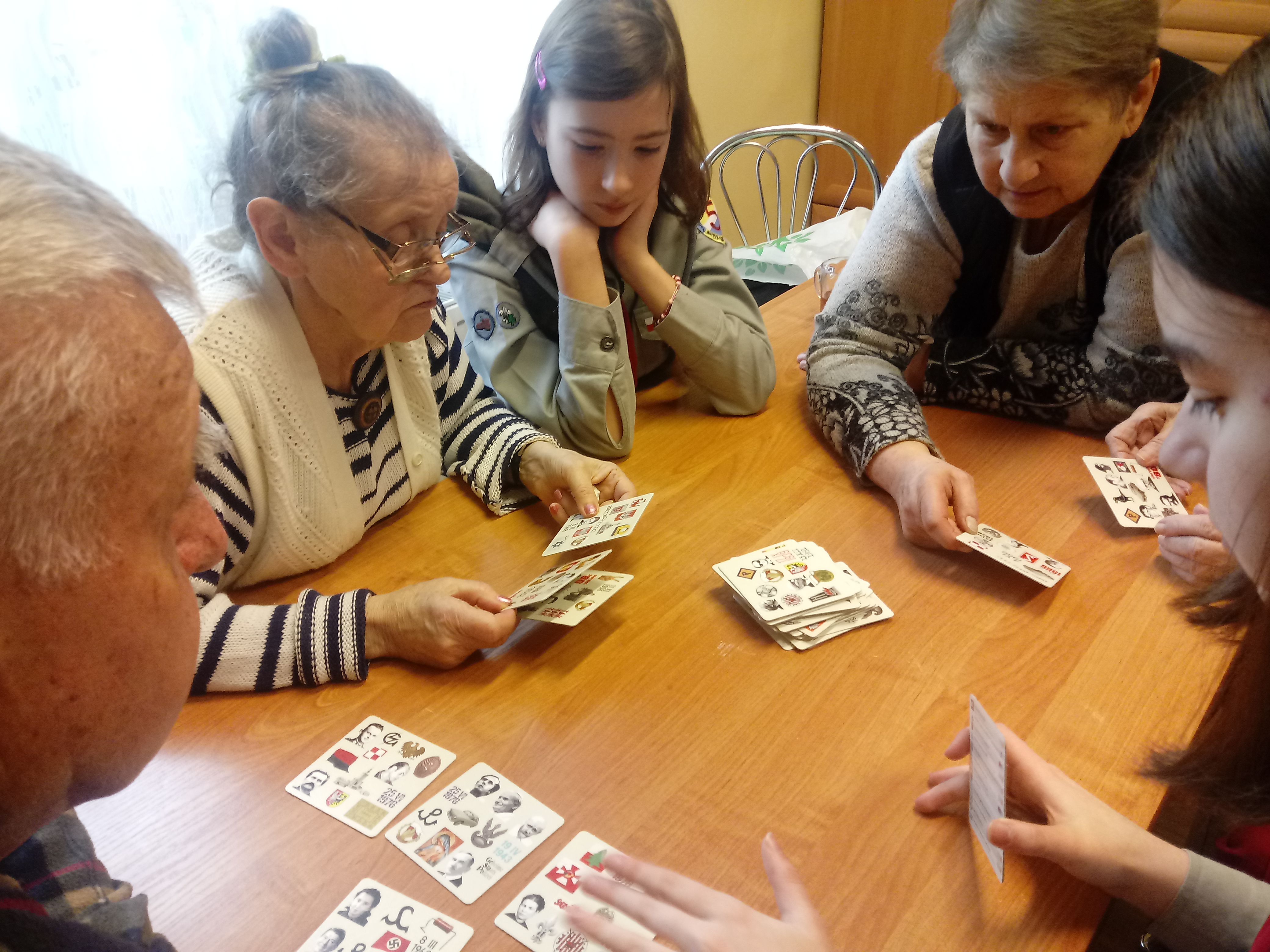 Seniorzy z harcerzami grają w karty