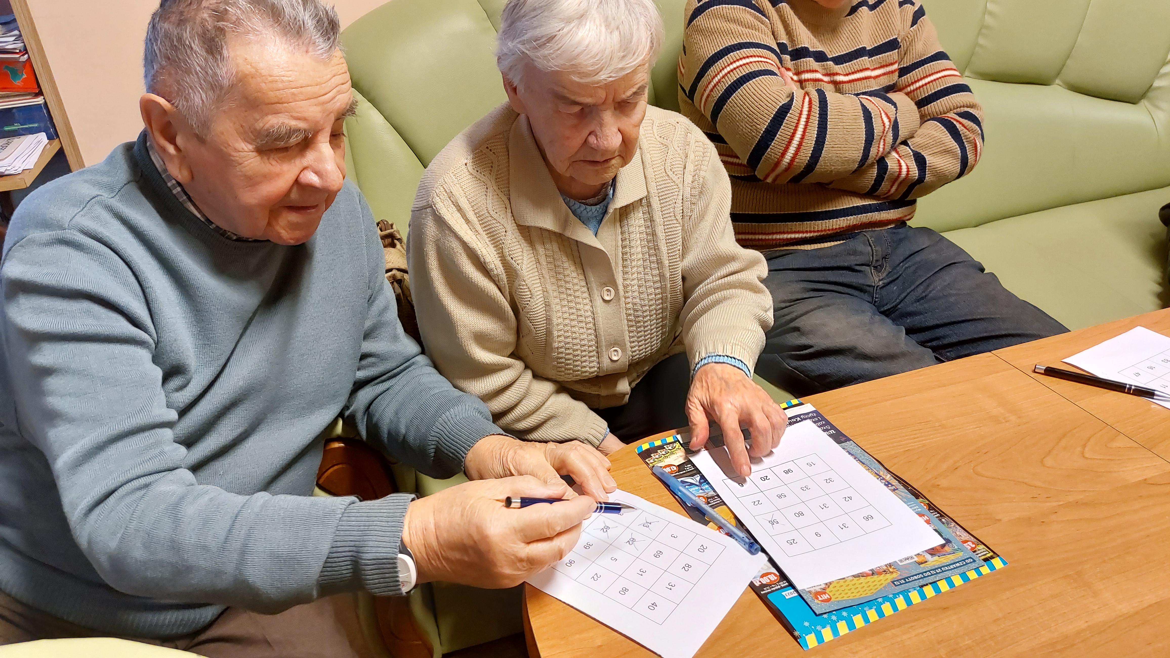 Dwoje Seniorów przy stole, rozwiązuje krzyżówki