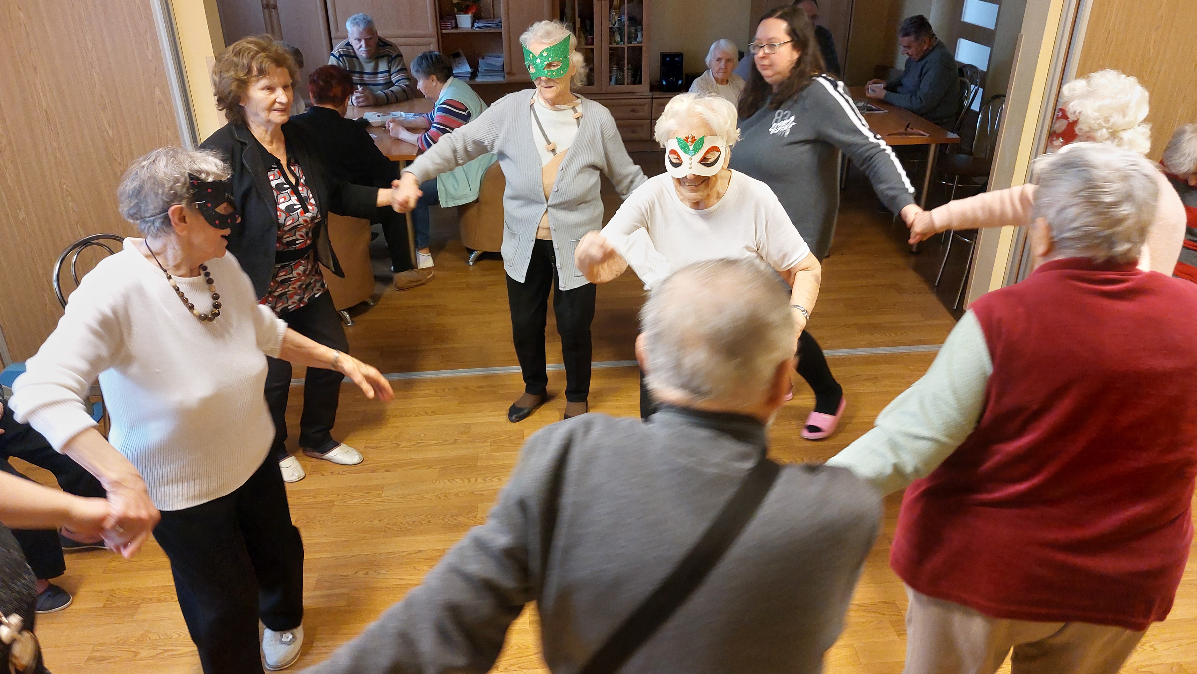 Grupa Seniorów tańczy w kółku