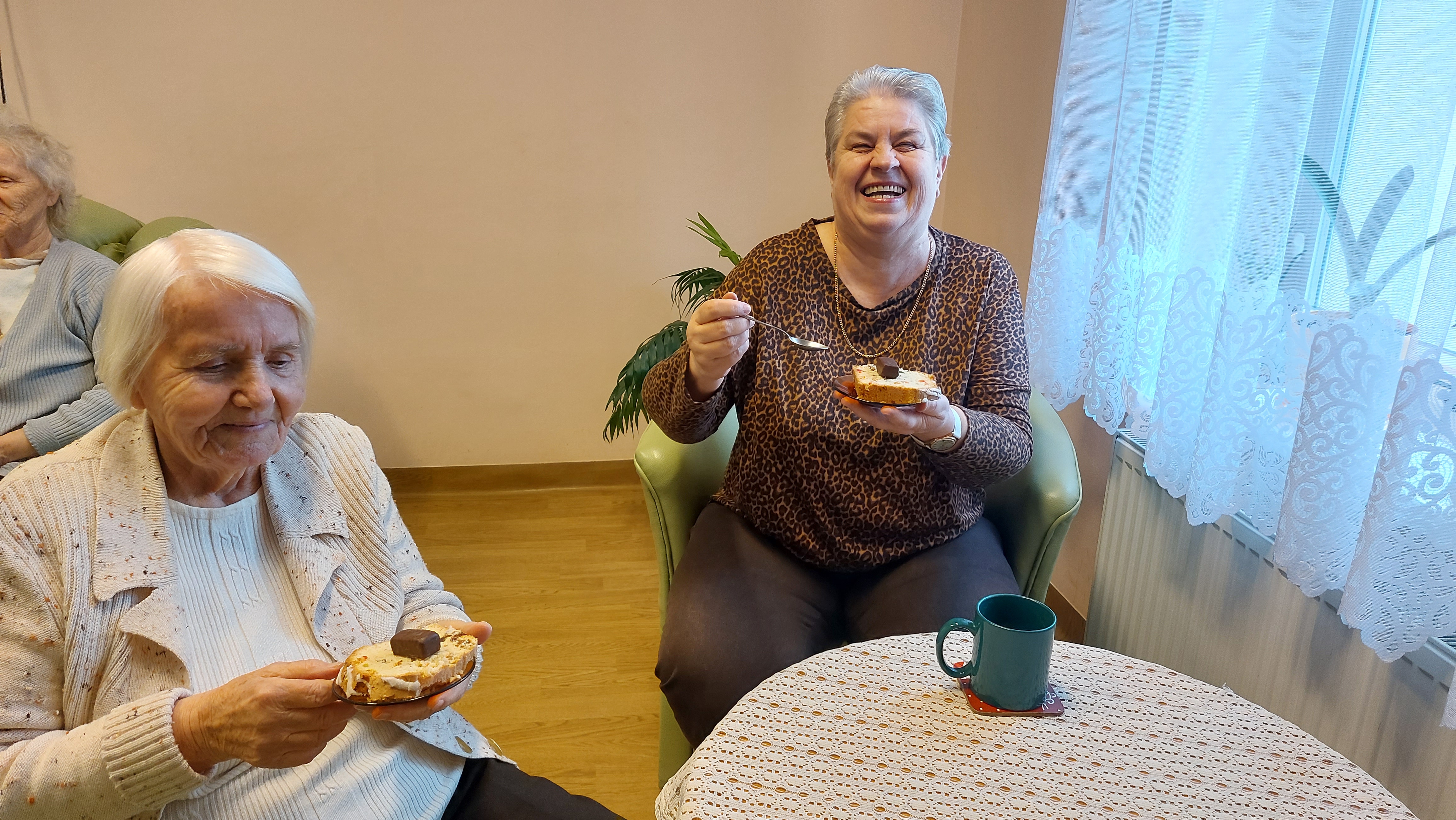Dwie Seniorki pozują z ciastkami, które mają na talerzykach