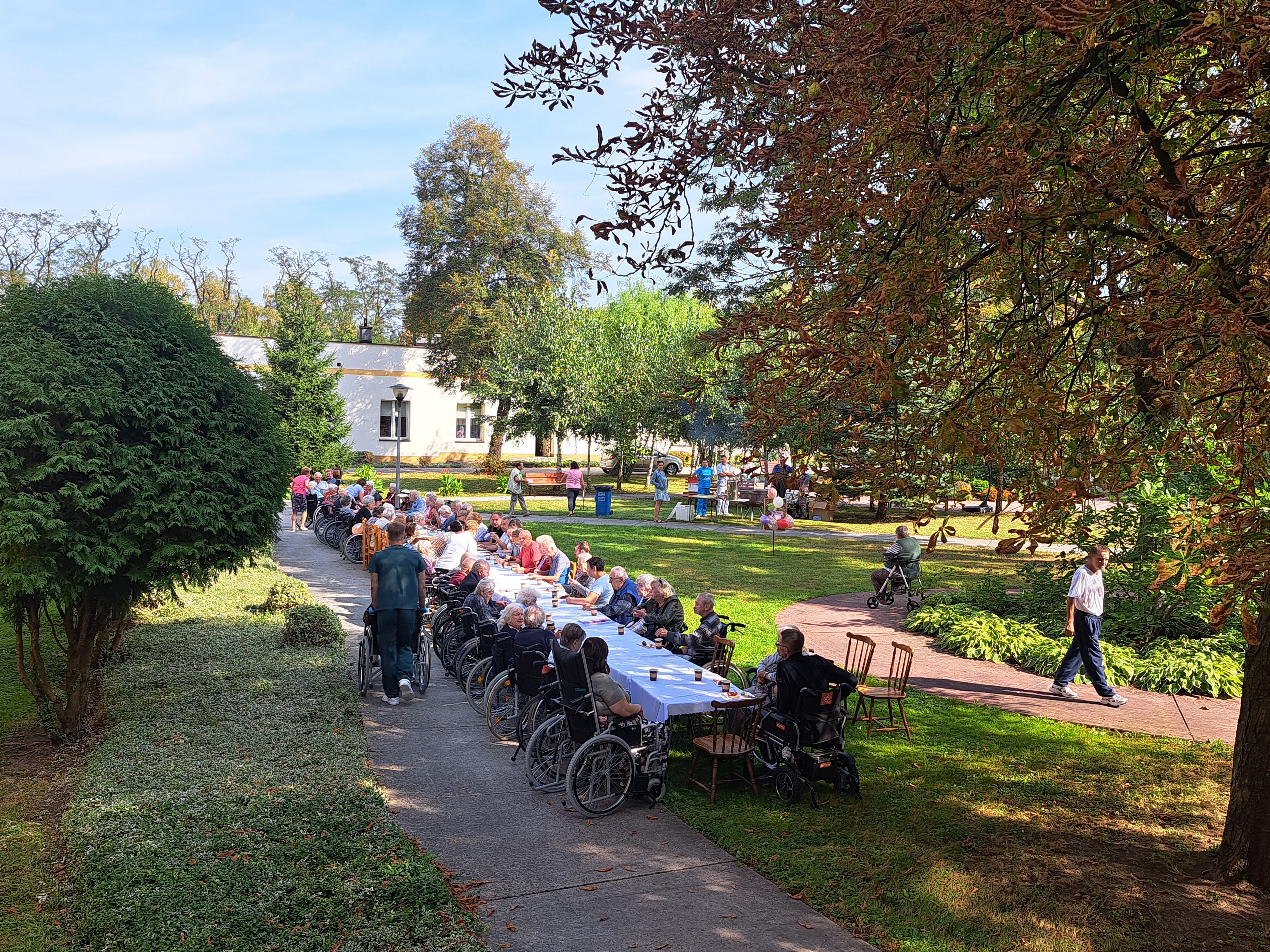 Senior pozuje ze zrobioną przez siebie zakładkę z kolorowego papieru