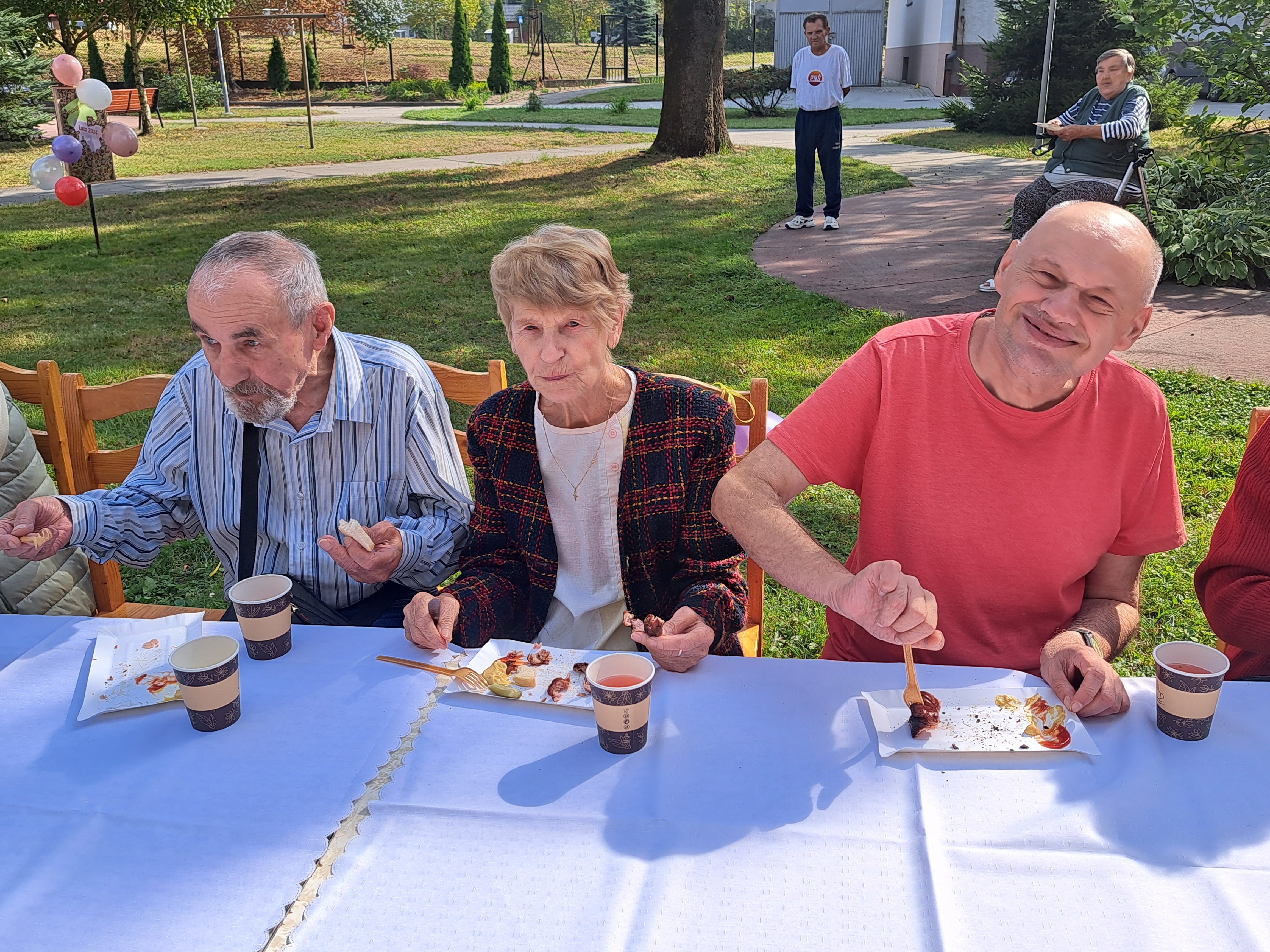 Senior pozuje ze zrobioną przez siebie zakładkę z kolorowego papieru