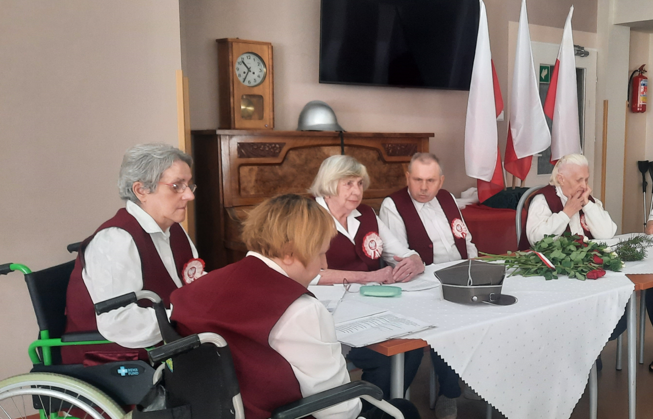 Seniorzy na tle polskiej flagi