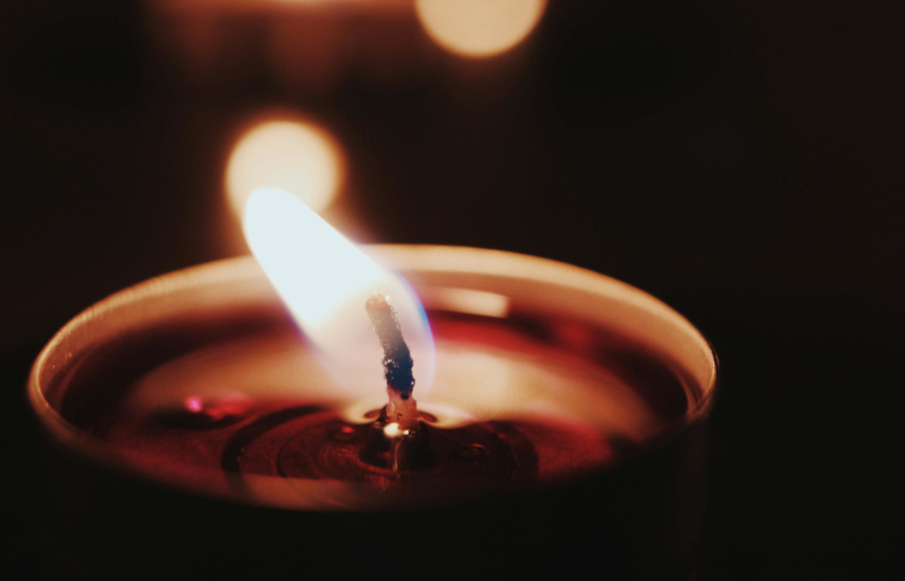 Płonący ogień świeczki, na czarnym tle
