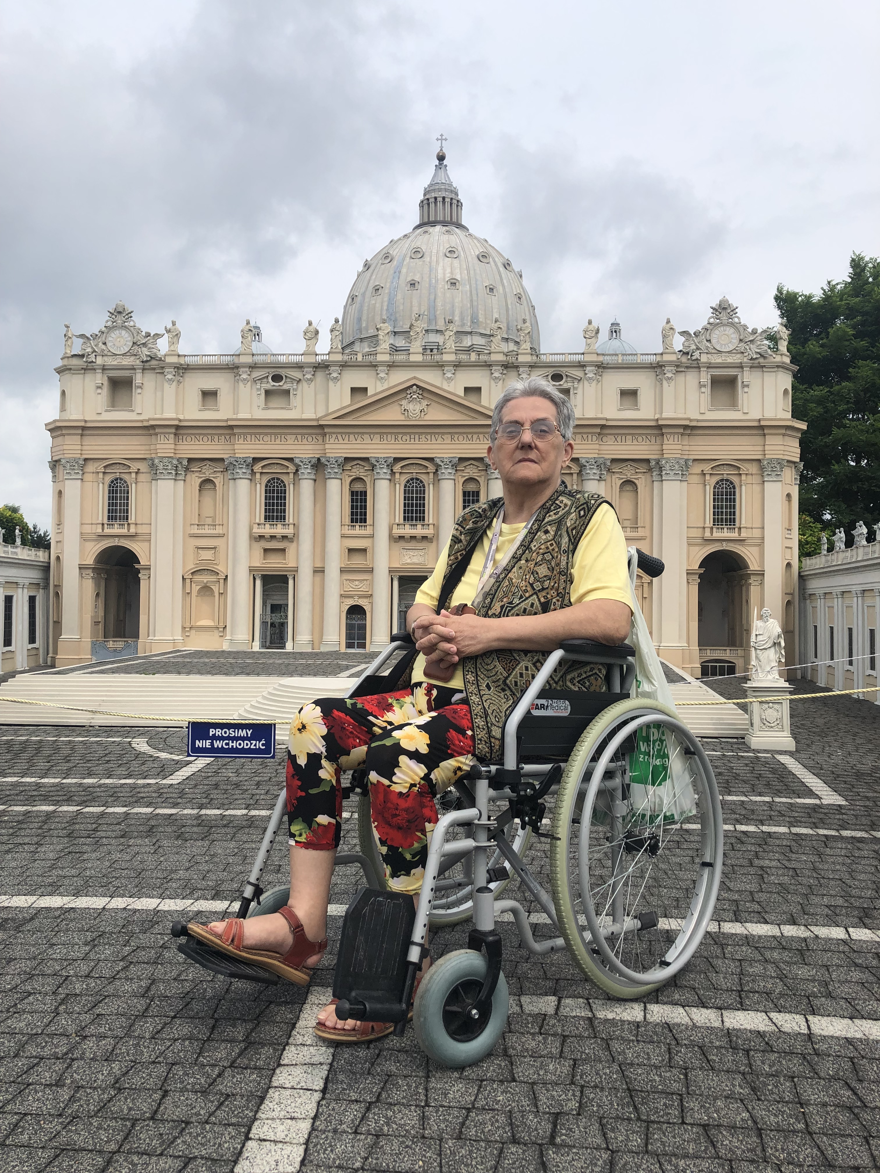 Seniorka na wózku, pozuje na tle miniaturowej Bazyliki Świętego Piotra