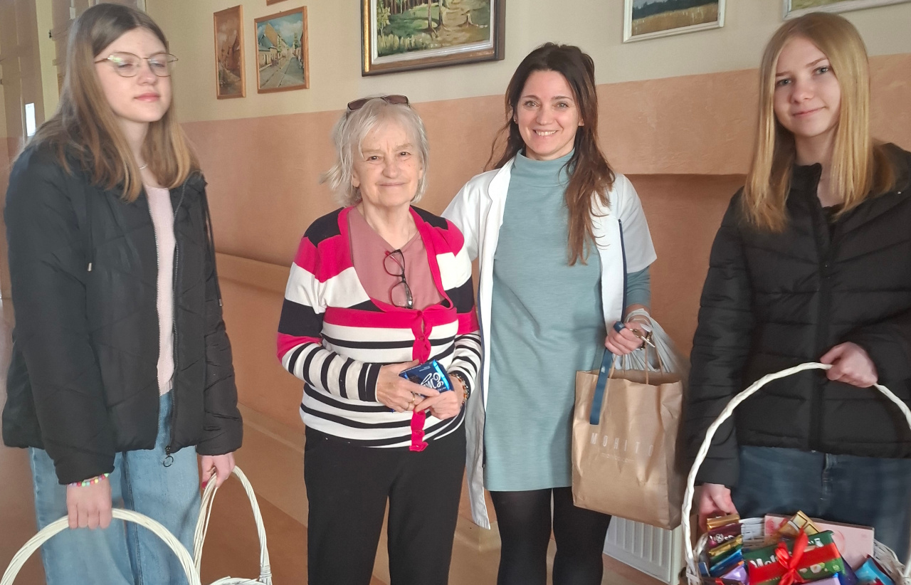 Uczennice, Seniorka oraz Pracowniczka działu Terapii pozują do zdjęcia