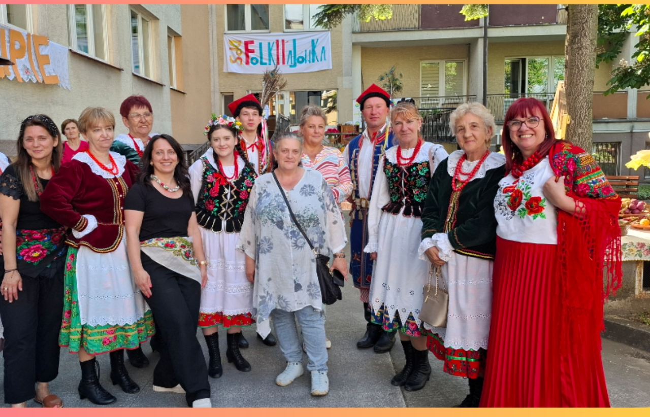 Pracownicy DOmu pozują do zdjęcia w folkowych strojach
