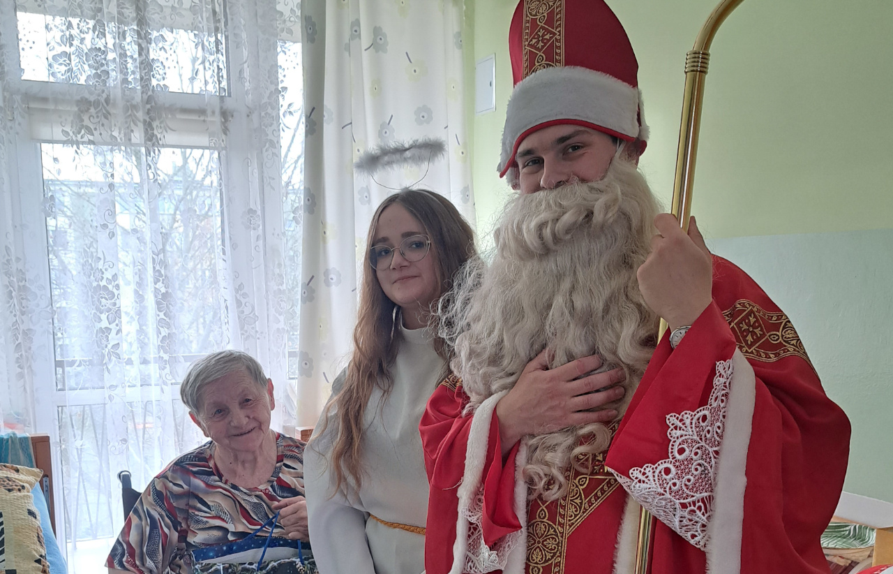 Święty Mikołaj, dziewczyna przebrana za Aniołka oraz Seniorka pozują do zdjęcia