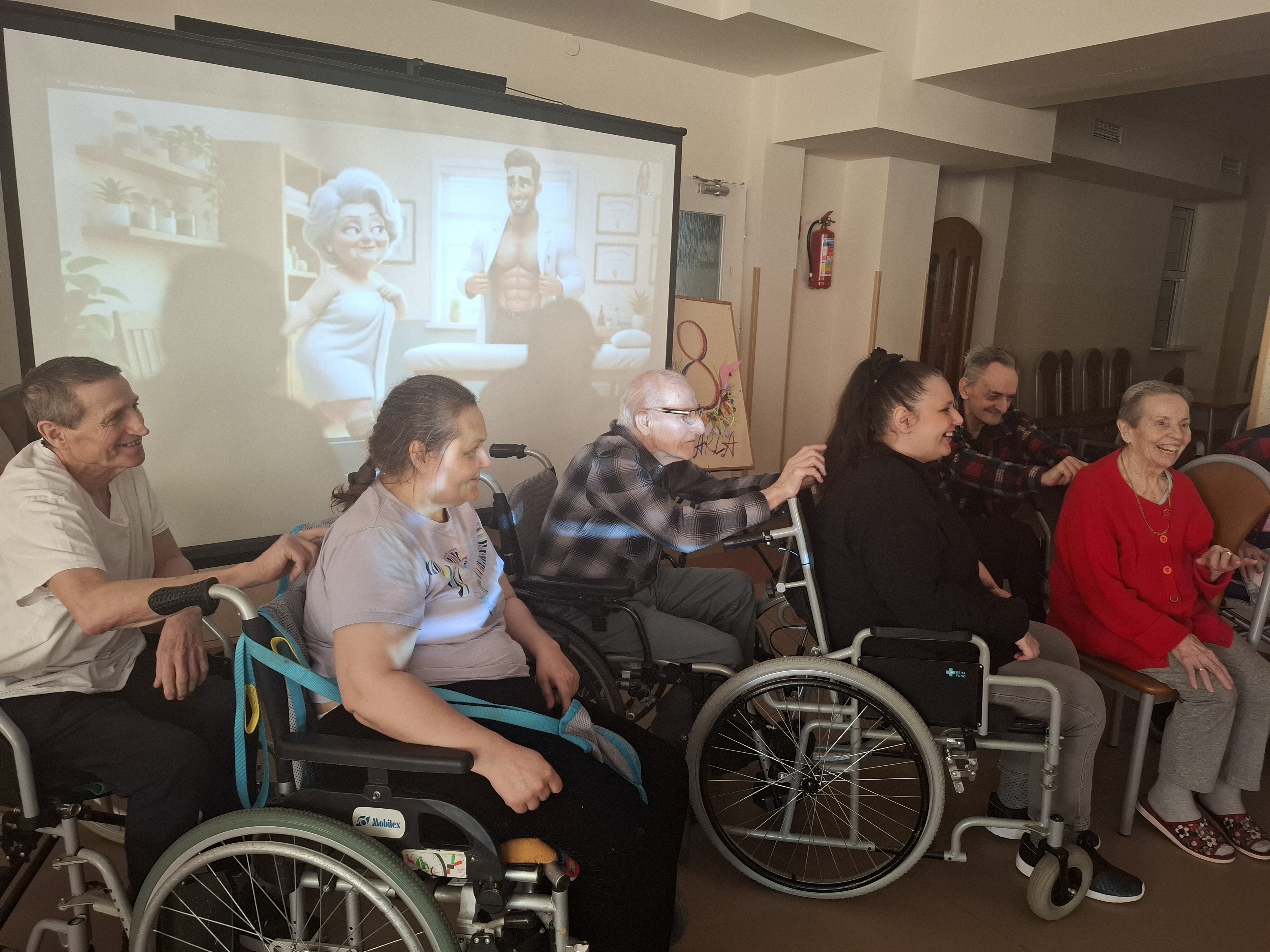 Seniorzy siedzą za Seniorkami wykonując im masaż relaksacyjny 