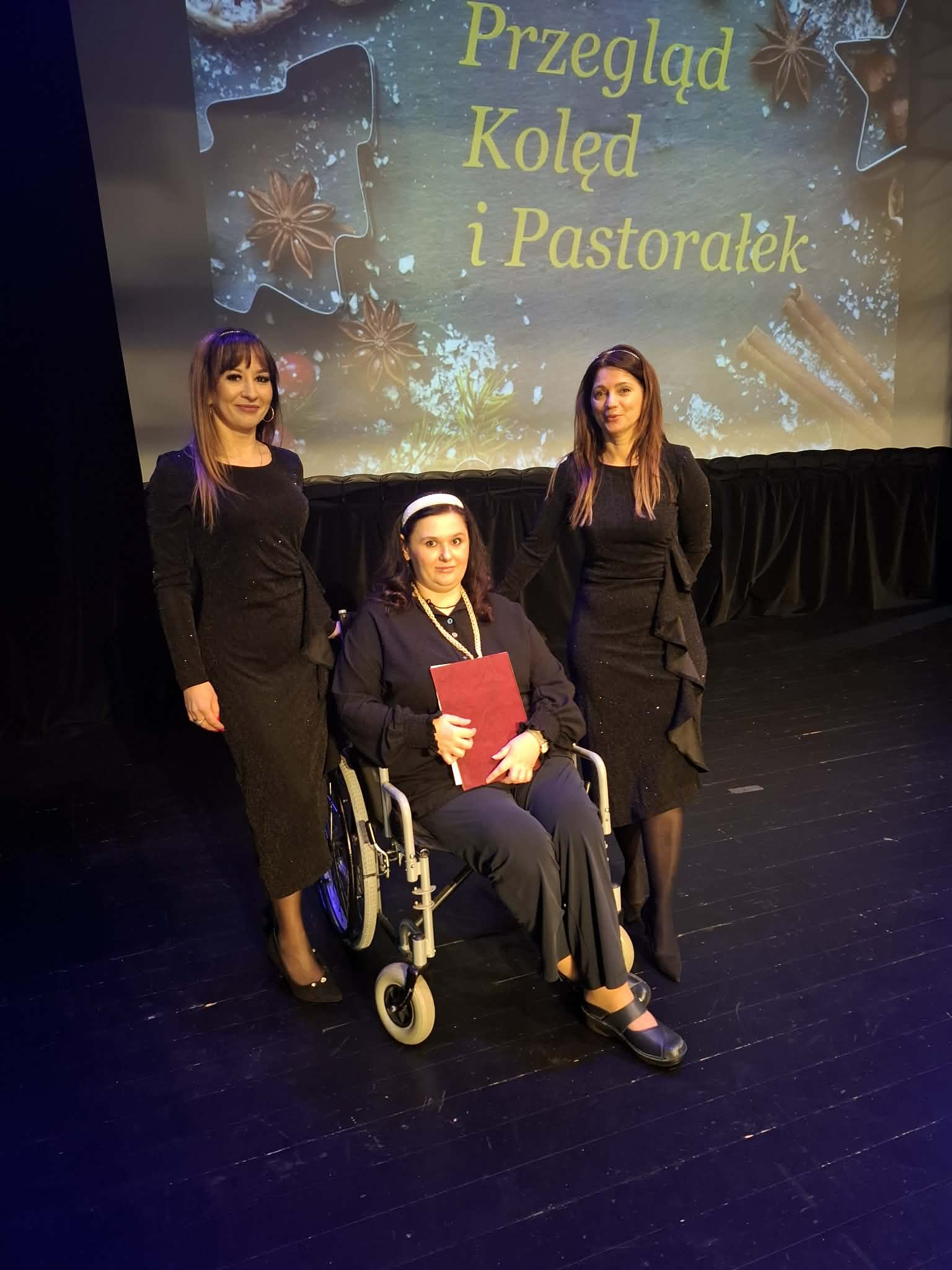 Pracownice Domu pozują do zdjęcia z kobietą siedzącą na wózku inwalidzkim